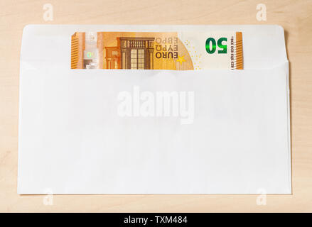 single fifty euro note in open mail envelope on wooden table Stock Photo