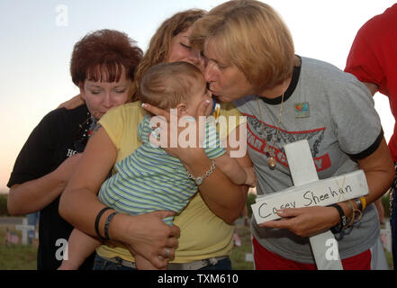 Peace demonstrator Cindy Sheehan (r) comforts Susan House, Melanie House and James House (8 months old) during a gathering at sunset at Camp Casey II near U.S. President George W. Bush's Crawford, Texas ranch on Aug. 24, 2005. Sheehan, whose son Casey died in Iraq in 2003, has been camped out near the ranch hoping to meet with the President for a second time and has drawn hundreds of peace demonstrators to the site. John house died in Iraq on Jan. 26, 2005, leaving his mother Susan, wife Melanie and son James, who he never met.  (UPI Photo/Roger L. Wollenberg) Stock Photo