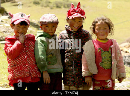 Tibetan children play near new farmhouses being built to replace homes destroyed by the 2014 earthquake near Kangding, a small county in the Ganzi Tibetan Autonomous Prefecture of Sichuan Province, on May 21, 2016.  China's central government is investing heavily in the development of the Tibetan Prefecture, building schools, roads, hydroelectric dams and general infrastructure projects.  The Tibetan area is normally off-limits to foreign journalists, with the Chinese government tightly controlling the prefecture's growth - which sometimes conflicts with the Tibetans' traditional way of life. Stock Photo