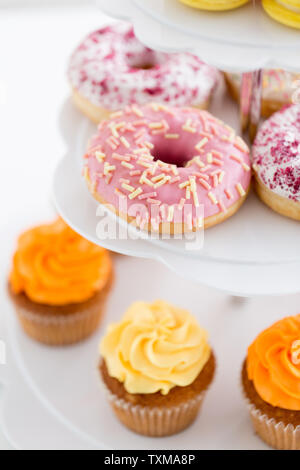 close up of glazed donuts and cupcakes on stand Stock Photo