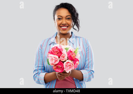 happy african american woman with bunch of flowers Stock Photo