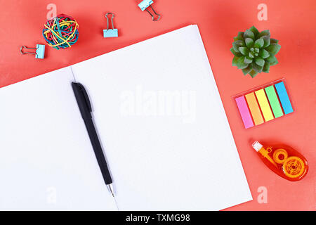 Blank notebook on the coral background, plant, keyboard. Top view, flat lay. Mockup, copy space. Stock Photo