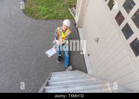 Injured architect sitting on the ground after having fallen off a ladder. Stock Photo