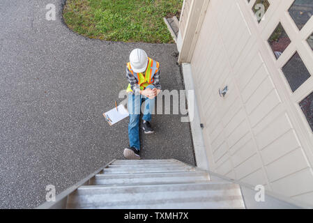 Injured architect sitting on the ground after having fallen off a ladder. Stock Photo