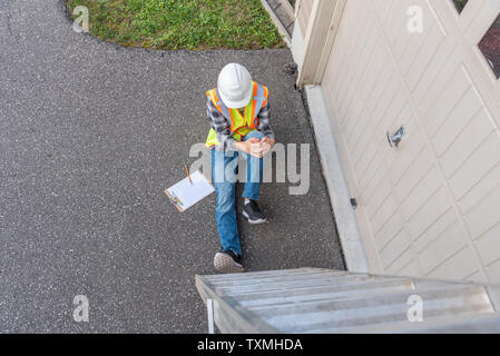 Injured architect sitting on the ground after having fallen off a ladder. Stock Photo