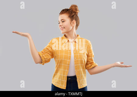 happy red haired teenage girl holding empty hands Stock Photo