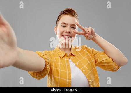 redhead teenage girl taking selfie making peace Stock Photo