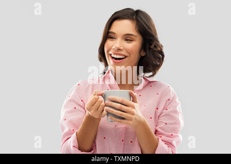 happy young woman in pajama with mug of coffee Stock Photo