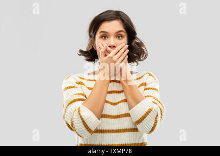 shocked young woman covering her mouth by hands Stock Photo
