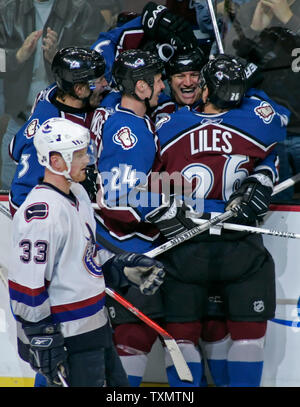 Colorado Avalanche right wing Dan Hinote (second from right) is mobbed by teammates (L-R) Karlis Skrastins, Antti Laaksonen, and John-Michael Liles after scoring in the third period against the Vancouver Canucks at the Pepsi Center in Denver November 27, 2005.  Canucks center Henrik Sedin (L) skates past the celebrating Avalanche players.   (UPI Photo/Gary C. Caskey) Stock Photo