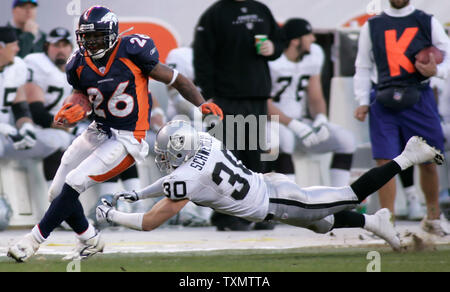 Denver Broncos running back Tatum Bell (L) breaks loose for a 20-yard gain  against Kansas City Chiefs linebacker Kawika Mitchell (R), in overtime at  Invesco Field in Denver on September 17, 2006.