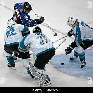 Colorado Avalanche right wing Dan Hinote (top) tries to slap a rebound past San Jose Sharks (L-R) Scott Hannan, goalie Vesa Toskala, and Josh Gorges at Pepsi Center in Denver April 5, 2006.  San Jose beat Colorado 2-1.  (UPI Photo/Gary C. Caskey) Stock Photo