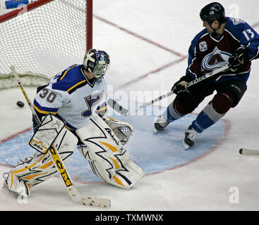 Colorado Avalanche right wing Dan Hinote (R) scores against the St. Louis Blues goalie Jason Bacashihua (L) in the third period at Pepsi Center in Denver April 8, 2006.  Colorado beat St. Louis 4-2 earning two valuable points in their race to win a spot in the Western Conference playoffs.  (UPI Photo/Gary C. Caskey) Stock Photo