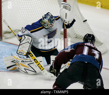 Colorado Avalanche right wing Dan Hinote (R) fires a shot at St. Louis Blues goalie Jason Bacashihua (L) at Pepsi Center in Denver April 8, 2006.  Colorado beat St. Louis 4-2.  (UPI Photo/Gary C. Caskey) Stock Photo