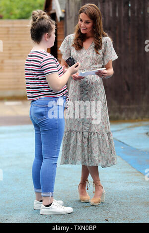 The Duchess of Cambridge talks to Ffion Turner during a Royal Photographic Society workshop with Action for Children which uses photography to help young people develop confidence and self-expression, at Warren Park Children's Centre, Kingston upon Thames. Stock Photo