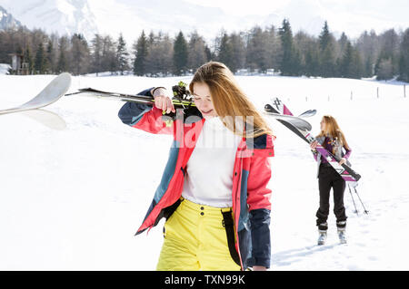 Two teenage girl skiers walking in snow covered landscape,  Tyrol, Styria, Austria Stock Photo