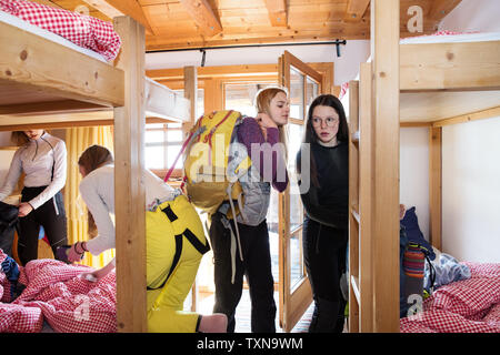 Four teenage girl skiers getting ready in cabin Stock Photo
