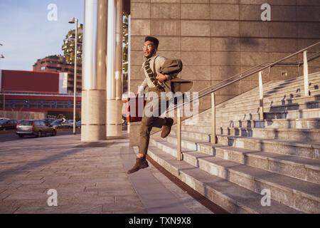Businessman jumping off stairs of office building, Milano, Lombardia, Italy Stock Photo