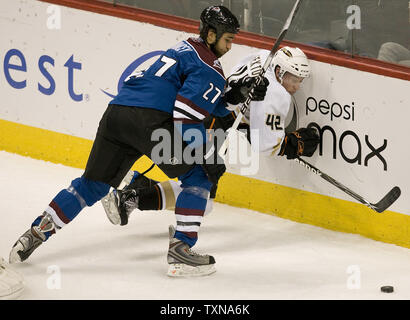 Colorado Avalanche defenseman Kyle Quincey (L) slams Anaheim Ducks right wing Dan Sexton into the boards behind the Avalanche net during the first period at the Pepsi Center in Denver on December 22, 2009.   UPI/Gary C. Caskey... Stock Photo