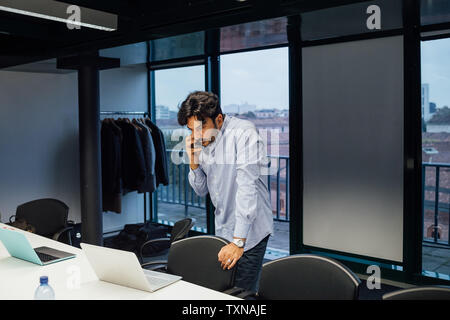 Businessman using smartphone in office Stock Photo