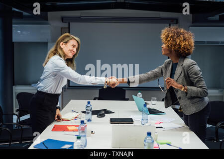Business partners shaking hands at meeting in office Stock Photo