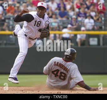 Colorado Rockies second baseman Jonathan Herrera (18) completes a double play over San Francisco Giants third baseman Pablo Sandoval in the eighth inning at Coors Field on July 4, 2010 in Denver.                 UPI/Gary C. Caskey Stock Photo