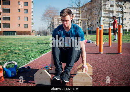 Calisthenics at outdoor gym, young man doing push ups Stock Photo