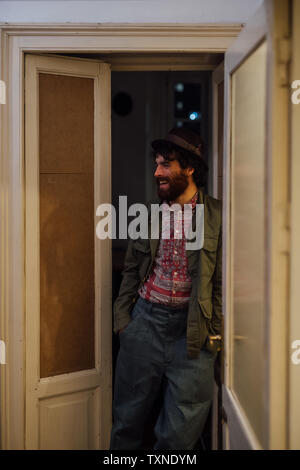 Bearded young man leaning against door Stock Photo