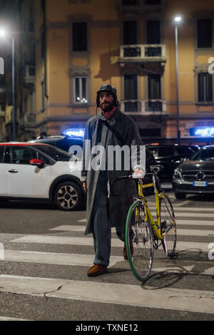 Bearded young man walking on pedestrian crossing with bicycle Stock Photo