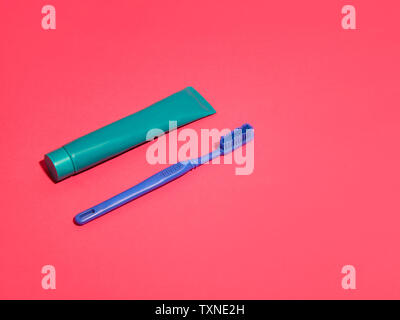 Toothbrush and toothpaste on red background Stock Photo