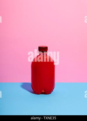 Still life with red plastic bottle and pink background Stock Photo