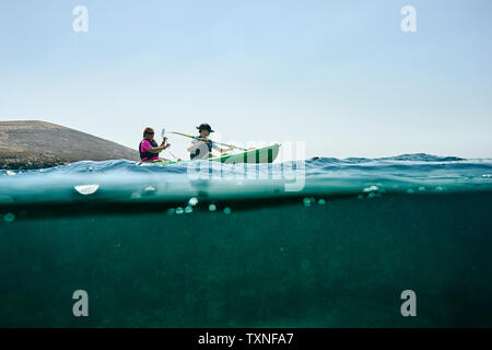 Teenage boy and mother sea kayaking, surface level side view, Limnos, Khios, Greece Stock Photo