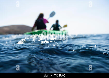 Teenage boy and mother sea kayaking, surface level shallow focus view, Limnos, Khios, Greece Stock Photo