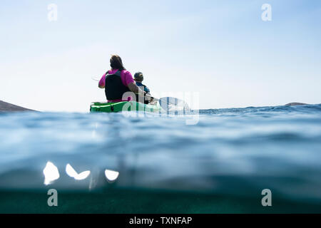 Teenage boy and mother sea kayaking, surface level rear view, Limnos, Khios, Greece Stock Photo