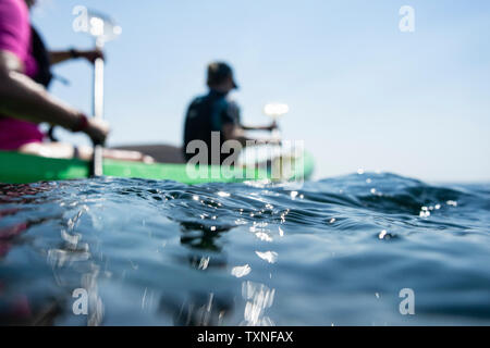 Teenage boy and mother sea kayaking, surface level shallow focus side view, Limnos, Khios, Greece Stock Photo