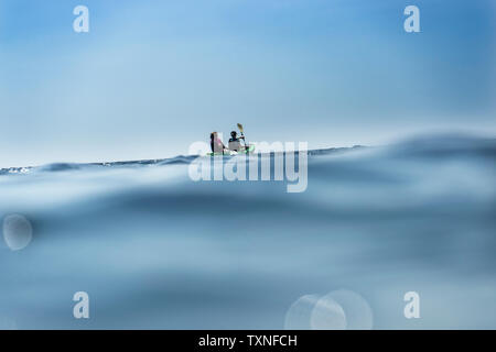 Teenage boy and mother sea kayaking, surface level distant view, Limnos, Khios, Greece Stock Photo