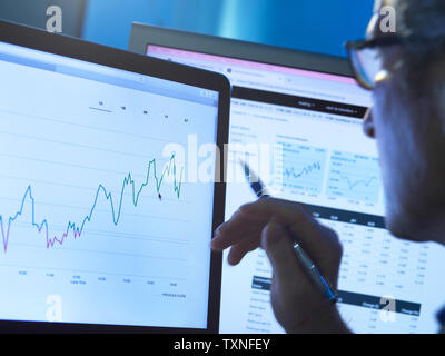 Financial services, stock analyst researching share price data of a company on the computer Stock Photo