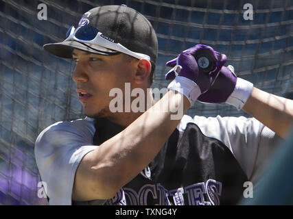 Colorado Rockies' Carlos Gonzalez takes a practice swing as he