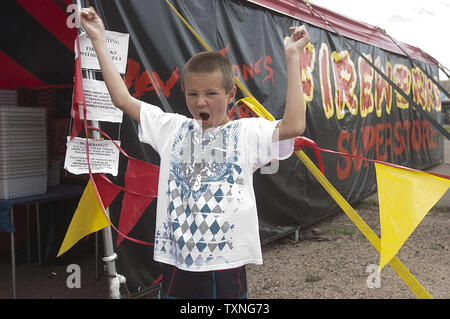 One youngster given a the bang of a free fireworks sample, shouts when it makes a bang during a buying spree at Davey Jones fireworks preceding Fourth of July Weekend in Lakewood, Colorado on June 30, 2011.       UPI/Gary C. Caskey Stock Photo