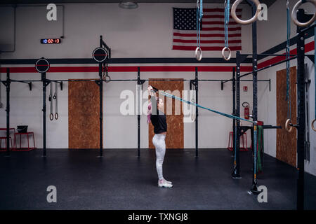 Young woman stretching arms in gym Stock Photo