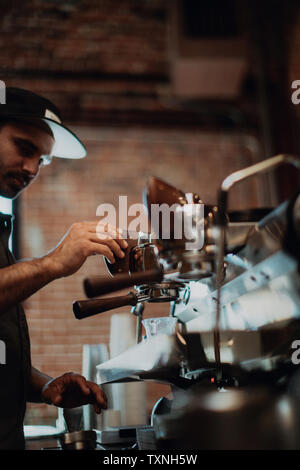 Barista using coffee machine in cafe, shallow focus side view Stock Photo