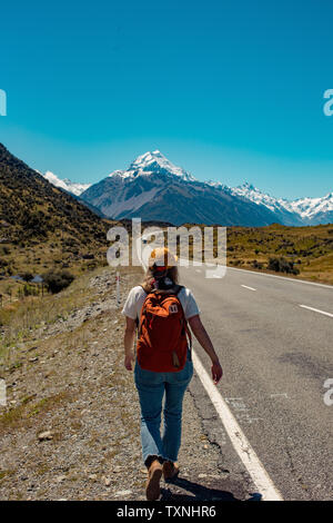 Hiker walking towards mountains, Wanaka, Taranaki, New Zealand Stock Photo