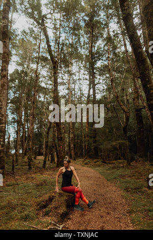Woman stretching in forest, Queenstown, Canterbury, New Zealand Stock Photo