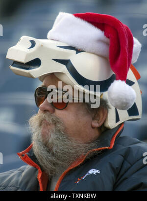 A Denver Broncos fan watches team warm ups surrounded by Broncos logos at  Sports Authority Field at Mile High on December 2, 2012 in Denver. Denver  clinches the AFC West division with