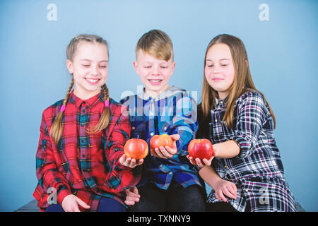 Teens with healthy snack. Healthy dieting and vitamin nutrition. Eat fruit and be healthy. Promoting healthy nutrition. Group teenagers cheerful kids hold apples. Boy and girls friends eat apple. Stock Photo