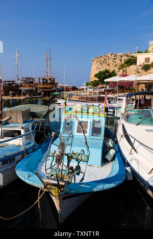 traditional Cypriot fishing boats moored alongside a modern speedboat, Kyrenia harbour and Castle, Girne, Turkish Republic of Northern Cyprus. Stock Photo