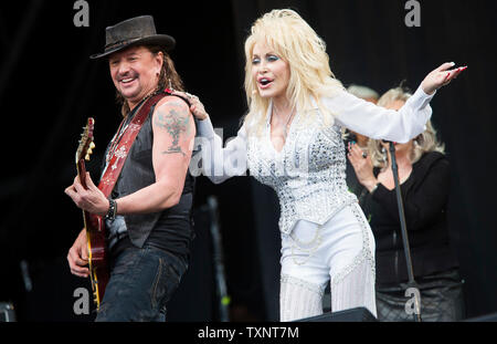 American country star Dolly Parton performing Lay Your Hands On Me with Bon Jovi guitarist Richie Sambora on the main Pyramid Stage of Glastonbury Festival in 2014. Glastonbury Festival of Contemporary Performing Arts is the largest music festival in UK, attracting over 135,000 people each to Pilton, Somerset. Stock Photo