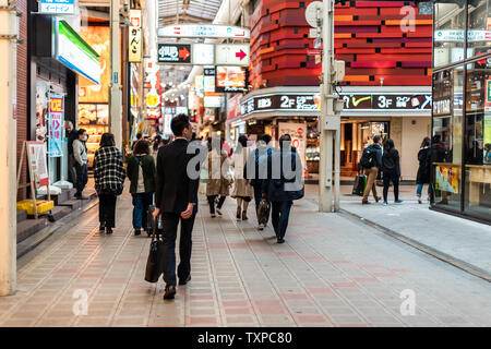 Osaka, Japan - April 13, 2019: Inside famous covered arcade street with people businessman salaryman walking shopping by stores shops Stock Photo