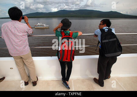 A Chinese tourist boat waits for passengers before heading up the Songhua River and its wetlands, which serves as a natural border between China and Russia (background), in Fuyuan, a frontier town in China's northern Heilongjiang Province on August 4, 2013. Ecotourism has been part of household vocabularies in China for a decade, however experts believe that the concept still has a long way to go in China.  Most domestic tourists are more interested in sightseeing than promoting environmental programs and awareness, according to a study.     UPI/Stephen Shaver Stock Photo