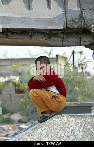 A boy sits in his destroyed home in the Kaweni slum on the outskirts of ...